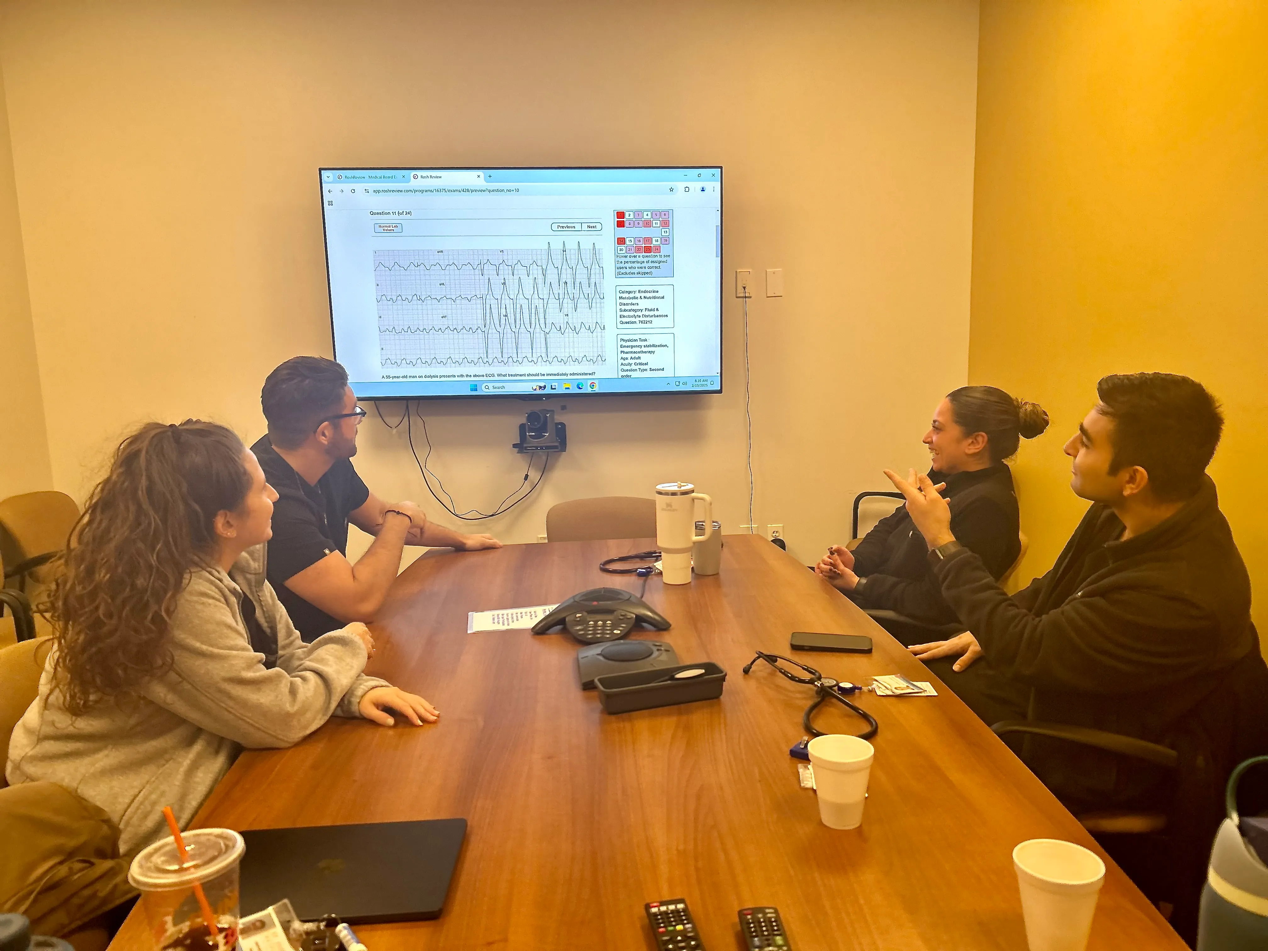 Residents around a conference table working through an ECG together